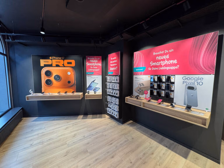 Der moderne Telefonshop von Tele-Planet zeigt Werbeplakate für das iPhone 17 Pro und das Google Pixel 10. Die Smartphones und das Zubehör sind ordentlich in Regalen und Wandregalen unter hellem Licht angeordnet.