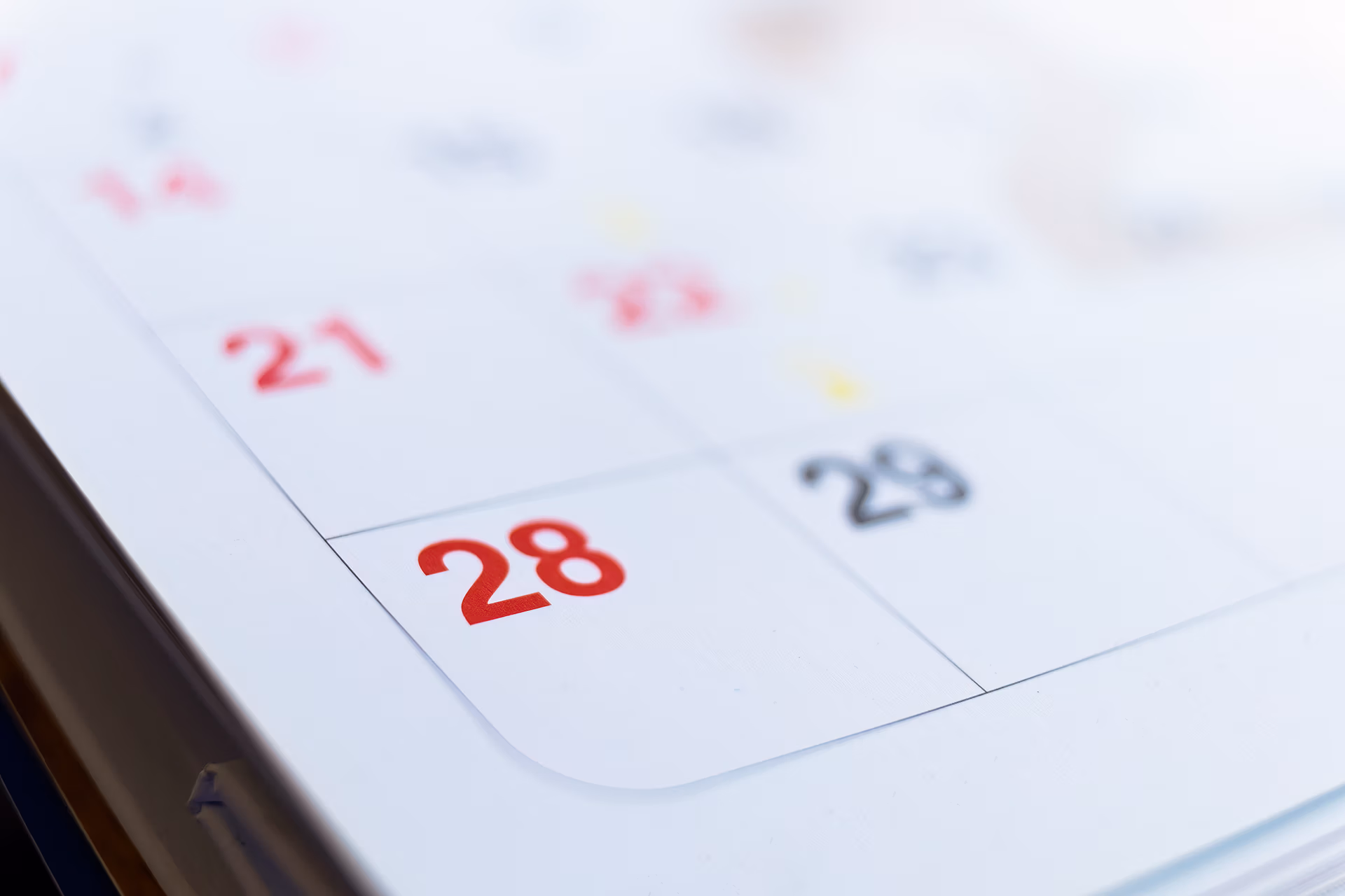 Nahaufnahme eines Tele-Planet-Kalenderblatts, das die Zahlen 21, 28 und 29 zeigt, wobei der 28. in Rot hervorgehoben ist. Das Bild ist an den Rändern leicht unscharf, um die Aufmerksamkeit auf diese wichtigen Daten zu lenken.