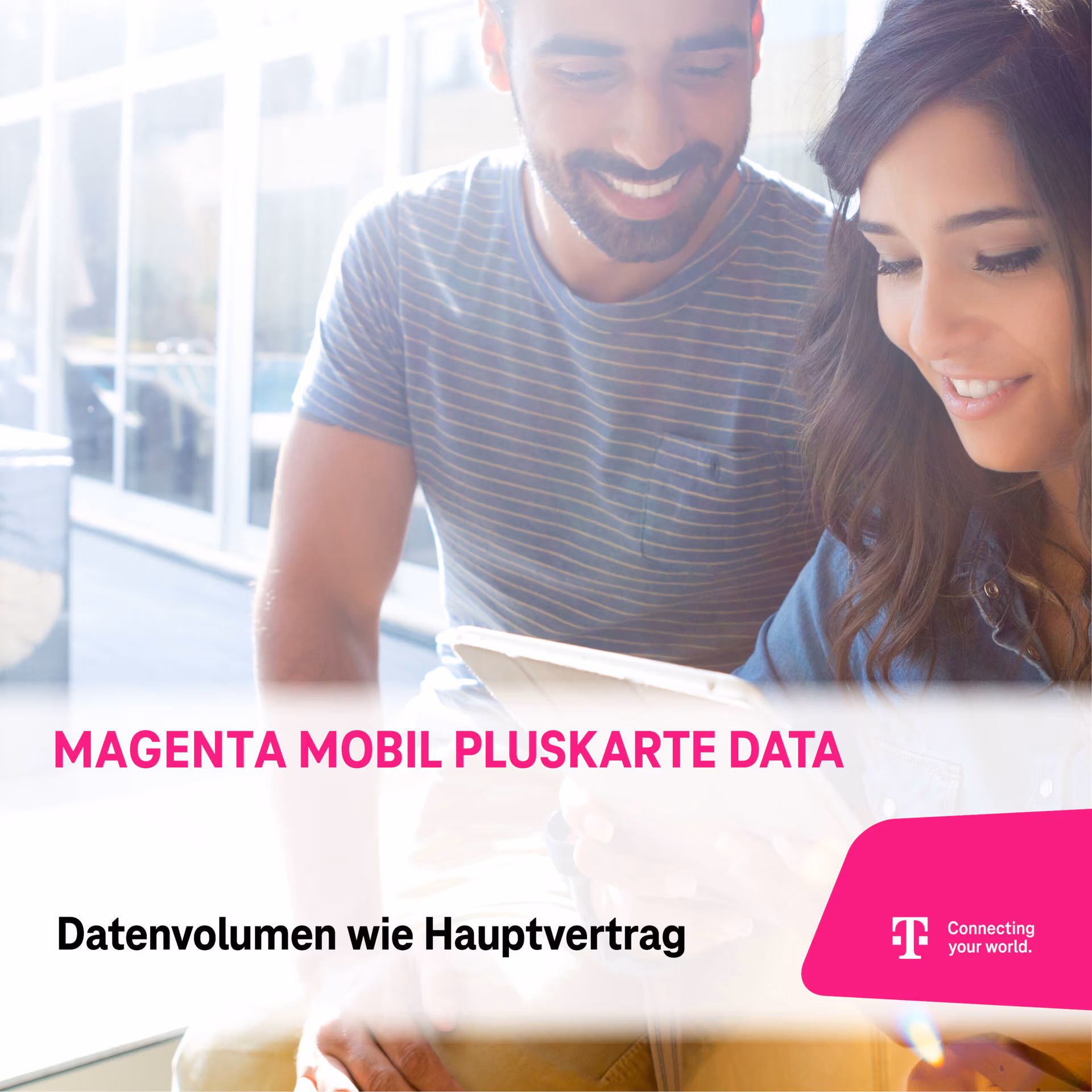 Ein lächelnder Mann und eine lächelnde Frau sitzen zusammen und schauen auf eine Tafel. Der Text lautet: "Magenta Mobil PlusKarte. Gleiches Datenvolumen wie im Hauptvertrag." In der Ecke sind Logo und Slogan der Telekom zu sehen.