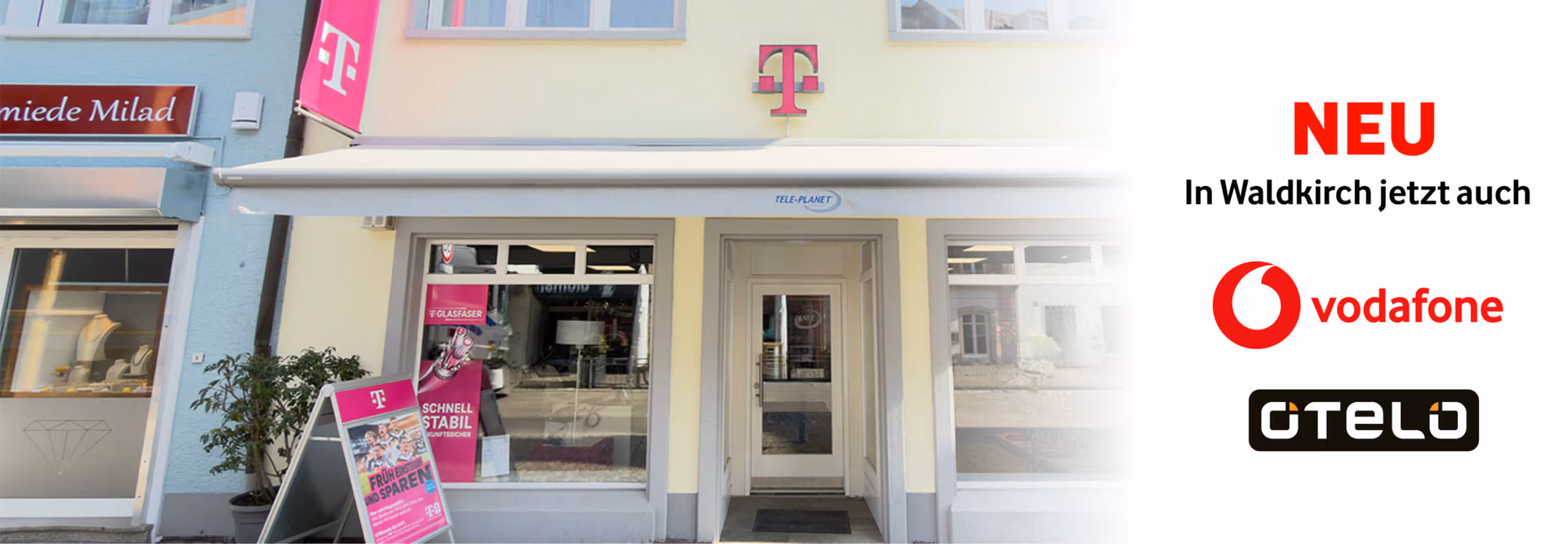 Schaufenster eines Telekom-Shops mit Schildern f&uuml;r Vodafone und Otelo auf wei&szlig;em Hintergrund; der Text "NEU, in Waldkirch jetzt auch" weist auf die neue Verf&uuml;gbarkeit in Waldkirch hin.